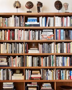 a bookshelf filled with lots of books next to a wall mounted vases