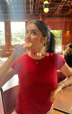 a woman in a red shirt is eating food