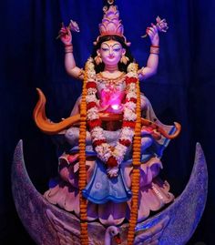 a statue of the hindu god ganesh in front of a blue background with lights