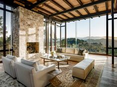 a living room filled with furniture and large windows