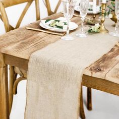 the table is set with place settings and wine glasses on it, along with napkins