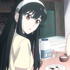 a girl with long black hair standing in front of a counter