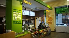 the inside of a fast food restaurant with green walls and signs on the wall that read pick up