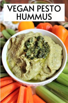 a white bowl filled with hummus surrounded by carrots and celery