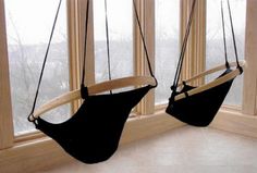 two hanging chairs in front of a window