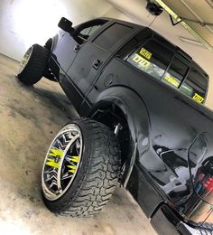 a black truck parked in a garage next to a wall