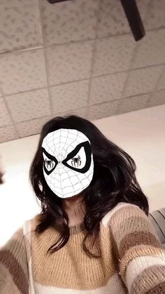 a woman wearing a spiderman mask with her eyes wide open and looking at the camera