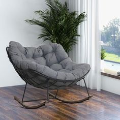 a chair that is sitting in the middle of a room with a potted plant