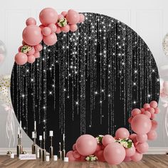 pink balloons and streamers in front of a black backdrop with white stars on it