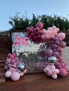 some pink and silver balloons are in front of a mirror