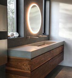 a bathroom with a sink, mirror and lights on the side of the wall in front of it