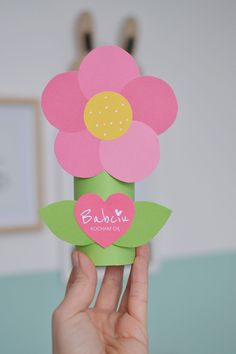 a person holding up a card with flowers on it