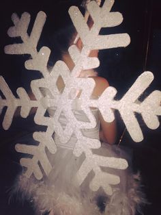 a woman standing in front of a mirror with snowflakes on it