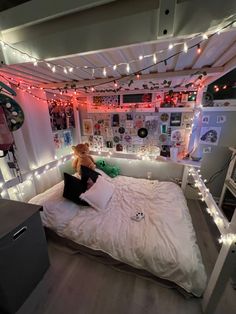 a bedroom with lights strung from the ceiling and a teddy bear sitting on the bed