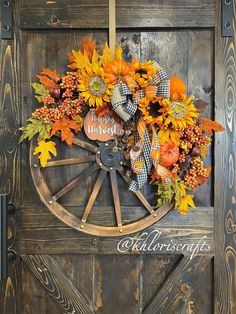 an old wagon wheel decorated with sunflowers and fall leaves is hung on the front door