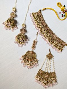 A semi-Indian bridal set is a stunning and elegant jewelry ensemble that beautifully combines elements of traditional Indian craftsmanship with modern design sensibilities. This exquisite set is designed for brides who wish to strike a perfect balance between traditional and contemporary aesthetics on their special day. The semi-Indian bridal set typically includes a harmonious combination of statement necklaces, earrings, tikka, and jummar all carefully crafted with intricate detailing and luxurious materials. These pieces enhance the bride's beauty and complement her wedding attire, whether a saree, lehenga or any other traditional outfit. One of the key features of this bridal set is its versatility. It effortlessly melds the opulence of Indian jewelry with more understated, modern elem Saree Lehenga, Traditional Outfit, Statement Necklaces, Bride Style, Traditional Indian, Bridal Set, Indian Bridal, Wedding Attire, Elegant Jewelry