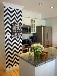 a kitchen with white cabinets and black and white chevron pattern on the door panels