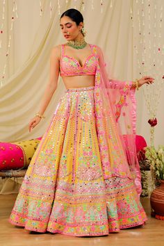 a woman in a yellow and pink lehenga