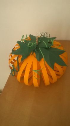 a paper pumpkin sitting on top of a wooden table