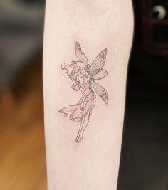 a small tattoo on the arm of a girl with a flower in her hair and a tinkerbell