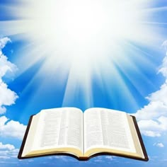 an open book is in the air with bright sun shining above it and blue sky