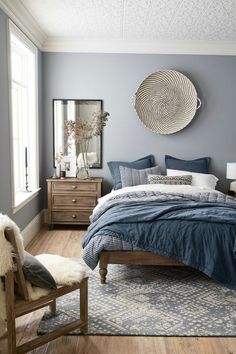 a bed room with a neatly made bed next to a window and a rug on the floor