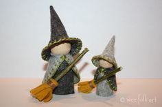 two small gnomes with hats and holding brooms