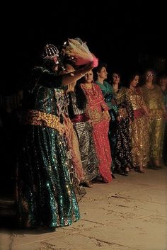 a group of people standing next to each other in front of a dark room with lights on