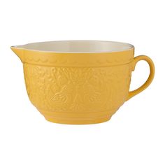 a yellow bowl with handles on the side and an ornate design in the middle, sitting on