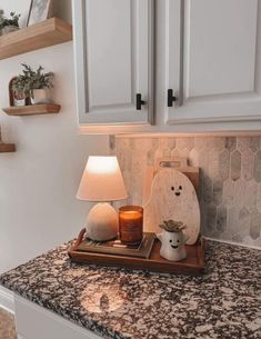 a kitchen counter with some candles on it and other items in front of the cabinets