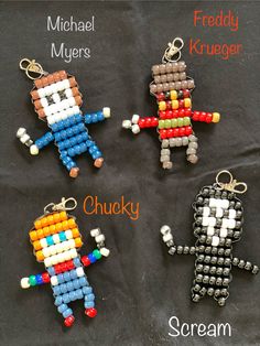 four different keychains made out of legos on a black cloth with the words scream, michael myers, kruger and chucky