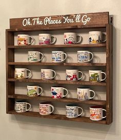 a wooden shelf with coffee mugs on it that says oh the places you'll go