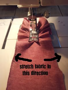 the sewing machine is on top of the fabric that has been stitched together with scissors