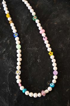 Revive the child in you with this playful and colorful Mother of Pearl charm necklace with assorted fun and colorful kidult beads. This necklace is a beautiful mix of classic elegance and youthful energy. The white Mother of Pearl beads give a timeless touch, while the kidult beads add a pop of color and playfulness. Mother of Pearl is a gemstone that is said to promote inner peace and emotional balance. The kidult beads add a touch of whimsy and fun, making this necklace a perfect accessory for Cute White Everyday Necklace, Cute Everyday White Necklace, Adjustable White Charm Necklaces With Letter Beads, White Adjustable Charm Necklace With Letter Beads, Whimsical White Jewelry With Pearl Charm, Handmade Playful White Jewelry, Playful White Handmade Jewelry, Everyday Adjustable White Necklaces, Everyday White Single Strand Beaded Necklace