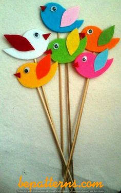 several colorful birds are sitting on top of toothpicks in the shape of flowers