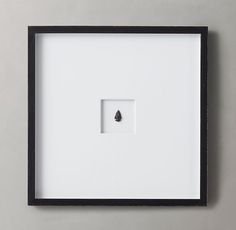 a black and white frame with a single piece of jewelry in the middle on a gray background