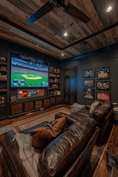 a man cave with leather couches and a large screen