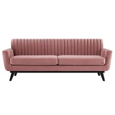 a pink velvet couch with black legs and arm rests on an isolated white background,