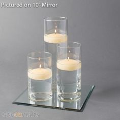 three candles sitting on top of a glass tray