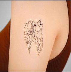 a woman's shoulder with a tattoo of two dogs on the left side of her arm