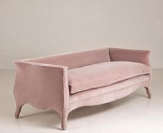 a pink couch sitting on top of a white floor