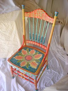 an old chair is decorated with beads and flowers