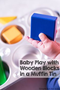 a baby playing with wooden blocks in a muffin tin for babies to play with