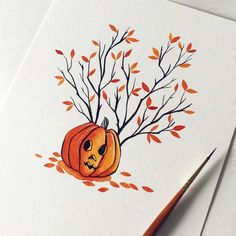 a drawing of a pumpkin with branches and leaves on it, next to a pencil