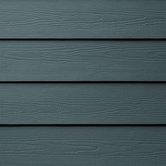 the side of a gray house with wood siding