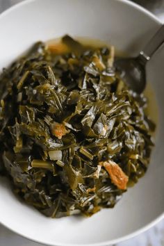 a white bowl filled with greens and carrots