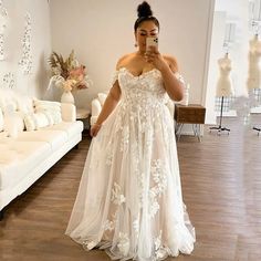 a woman is taking a selfie in her wedding dress while looking at her phone