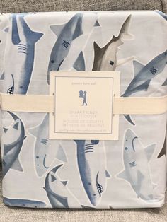 a blue and white blanket with sharks on it