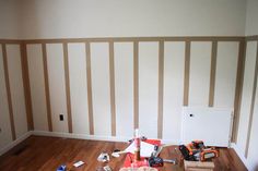 an empty room with hard wood flooring and construction tools scattered on the wooden floor