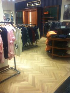 a clothing store with wooden floors and clothes on racks